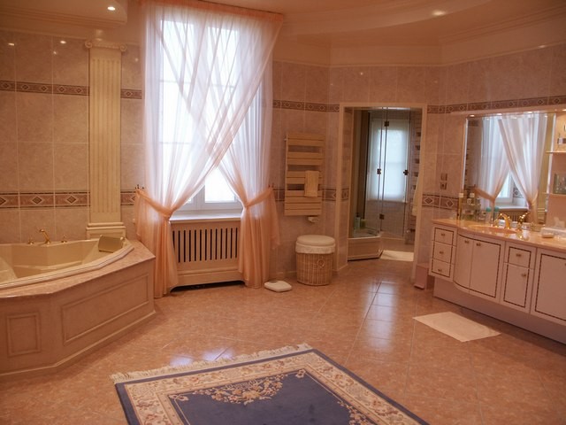 Une luxueuse salle de bain (avec baignoire, douche, lavabos et wc)