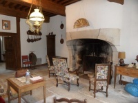 séjour avec de superbe éléments : rare cheminée en pierre; dalles au sol, plafond à la française ....
